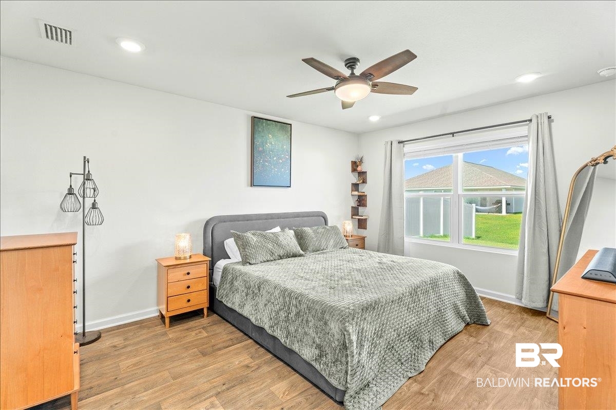 23641 Unbridled Loop Daphne, AL 36526 - Photo 18 of 40 Spacious interior featuring wood-finish flooring, a ceiling fan with integrated lighting, recessed lighting, and a double window with a backyard outlook