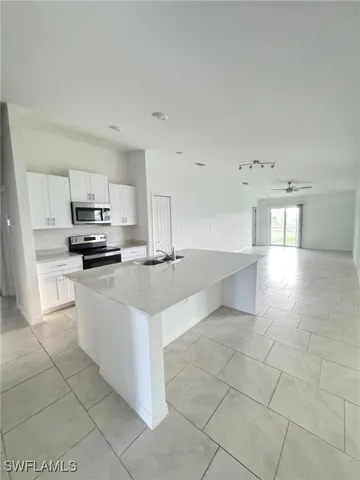 a kitchen with stainless steel appliances a sink a stove a microwave and a refrigerator