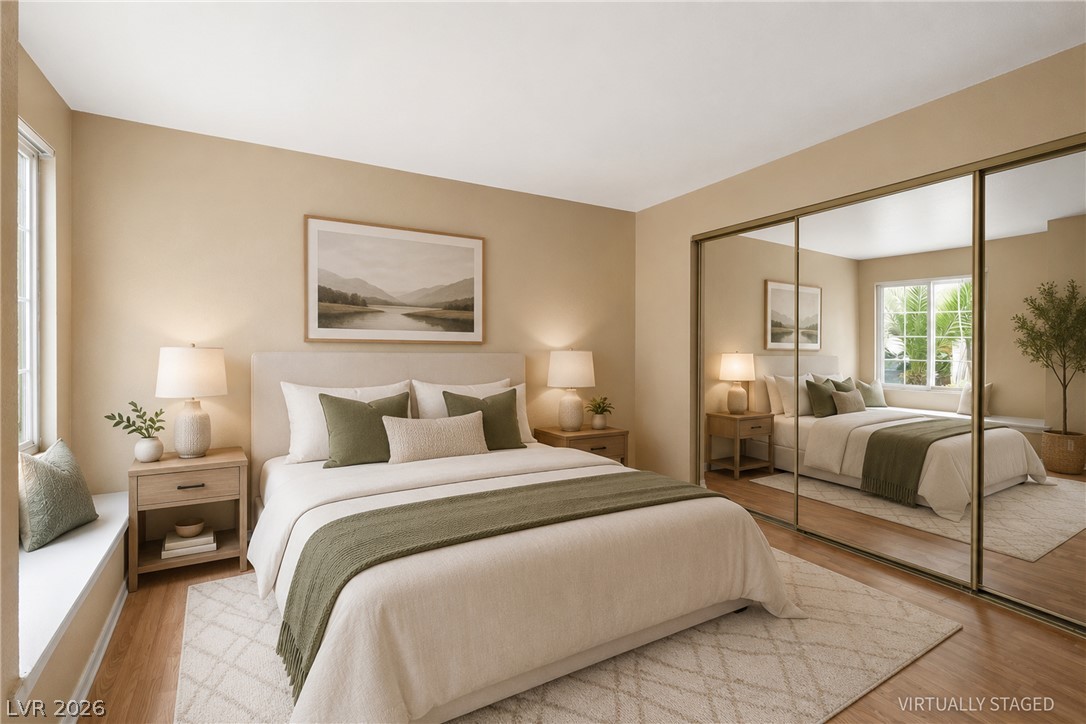A tranquil bedroom features warm tones, a wide window seat, and mirrored closet doors.