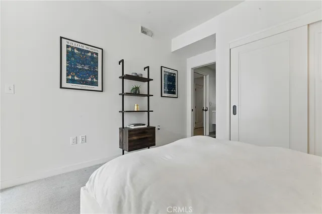 a bedroom with a bed and painting on the wall