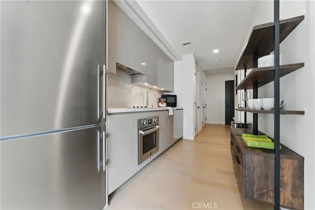 a kitchen with stainless steel appliances a refrigerator and a stove top oven