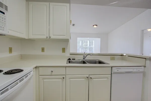 a kitchen with white cabinets and white appliances