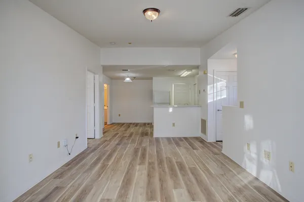 a view of a room with wooden floor and windows