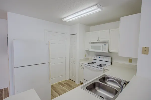 a kitchen with a refrigerator a stove top oven and a sink