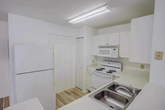 a kitchen with a refrigerator a stove top oven and a sink