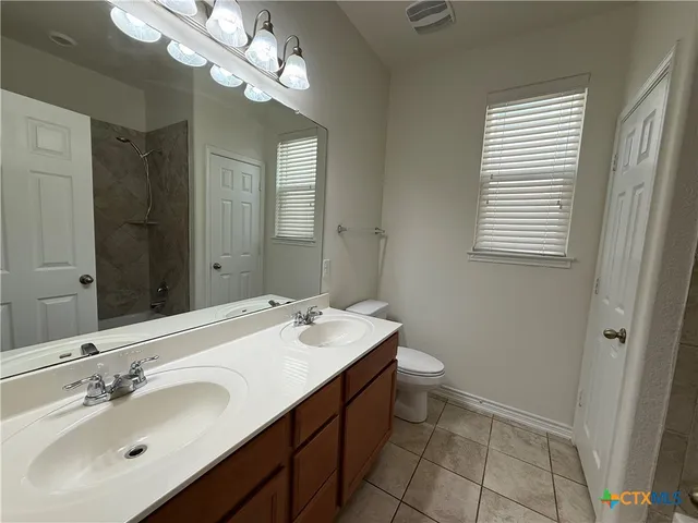a bathroom with a sink a toilet and a mirror