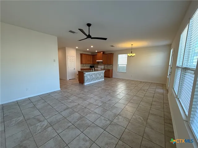 an empty room & kitchen view