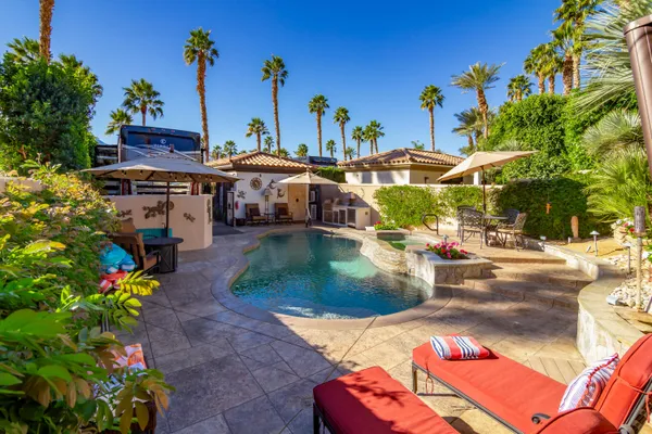 a view of a patio with couches table and chairs potted plants