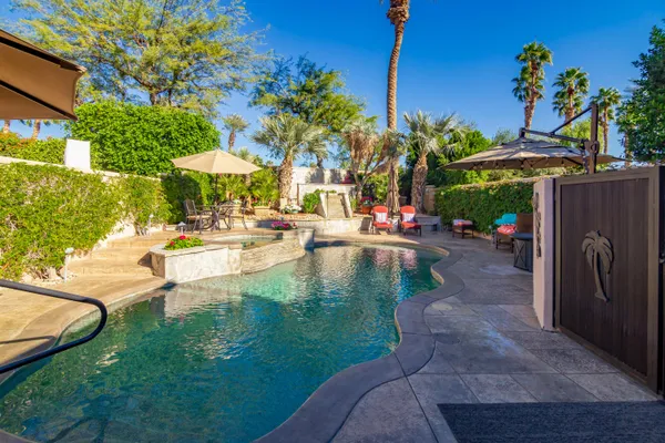 a view of a patio with a table and chairs under an umbrella