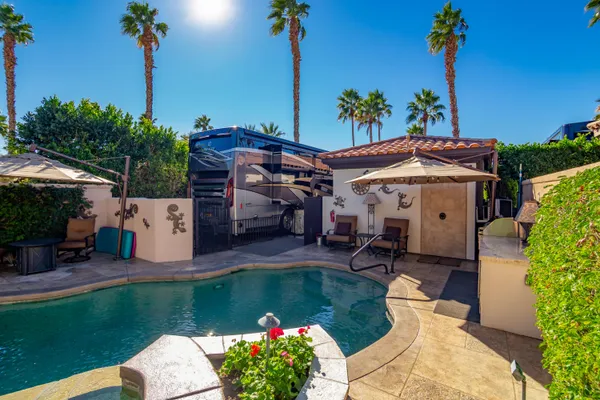 a view of a backyard with table and chairs under an umbrella