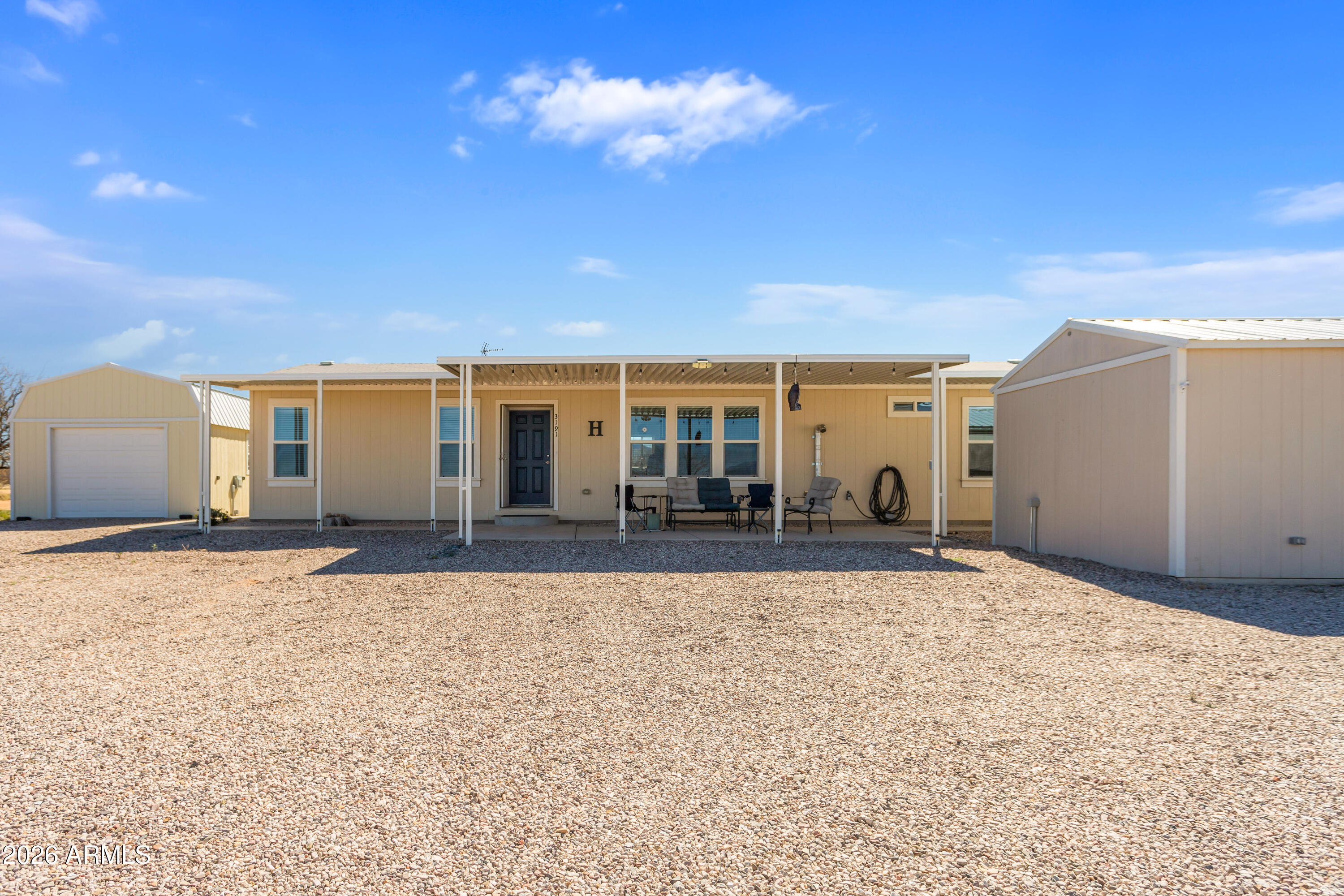 3191 West Williams Road Benson, AZ 85602 - Photo 2 of 46 a view of a house with backyard and a tree