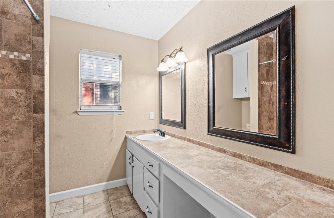 1910 Cherokee Street Corpus Christi, TX 78409 - Photo 11 of 23 a bathroom with a granite countertop sink and a mirror