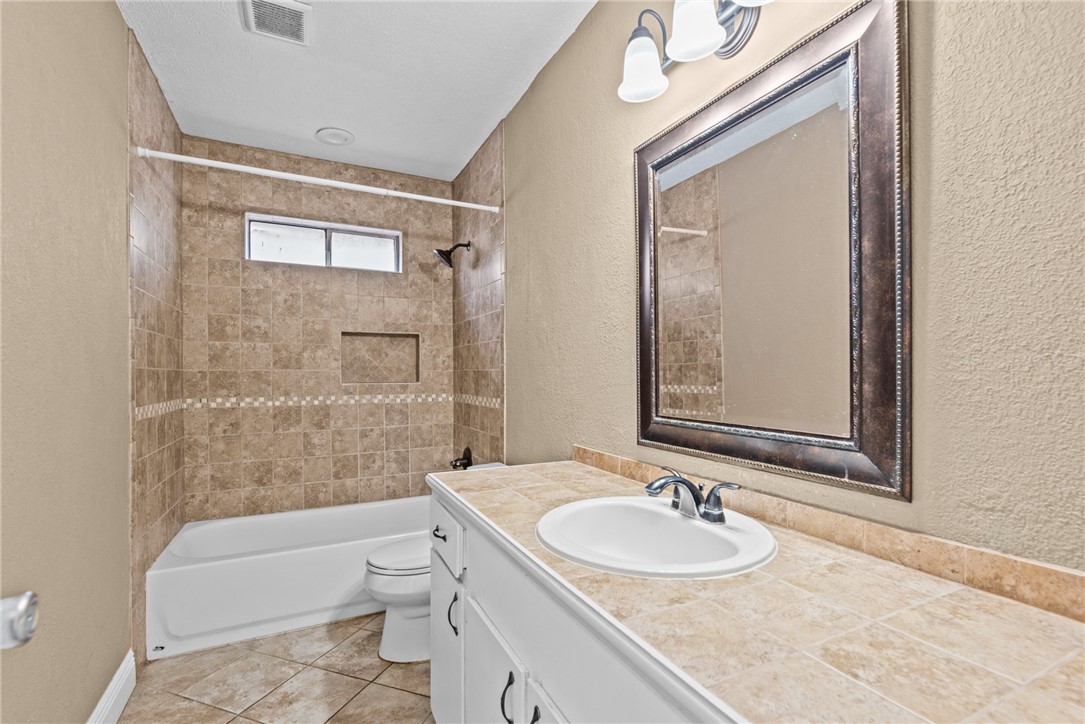 1910 Cherokee Street Corpus Christi, TX 78409 - Photo 15 of 23 a bathroom with a granite countertop sink a toilet and shower