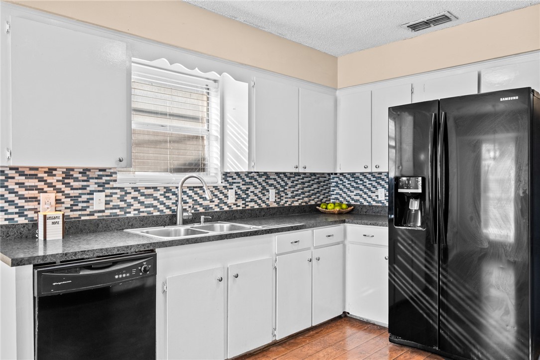 1910 Cherokee Street Corpus Christi, TX 78409 - Photo 7 of 23 a kitchen with granite countertop a refrigerator and a sink