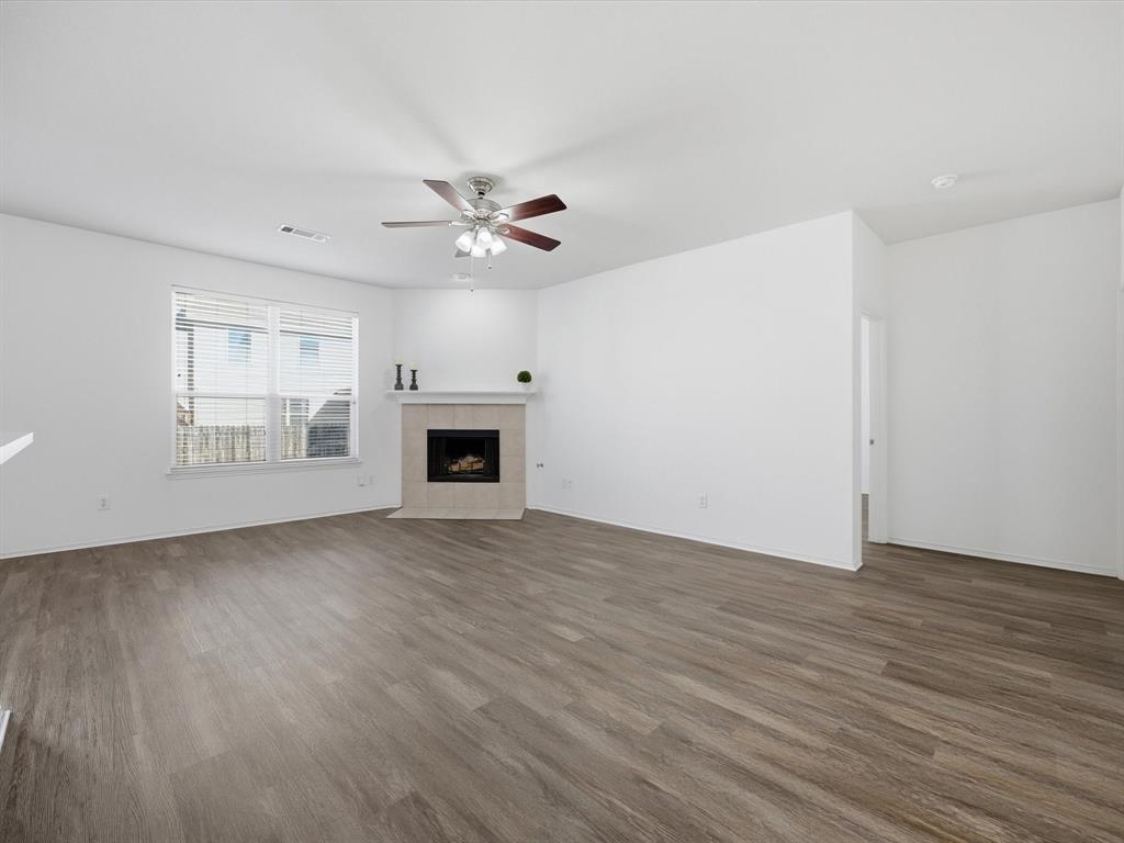 13264 Fencerow Road Fort Worth, TX 76244 - Photo 11 of 26 an empty room with wooden floor ceiling fan and windows