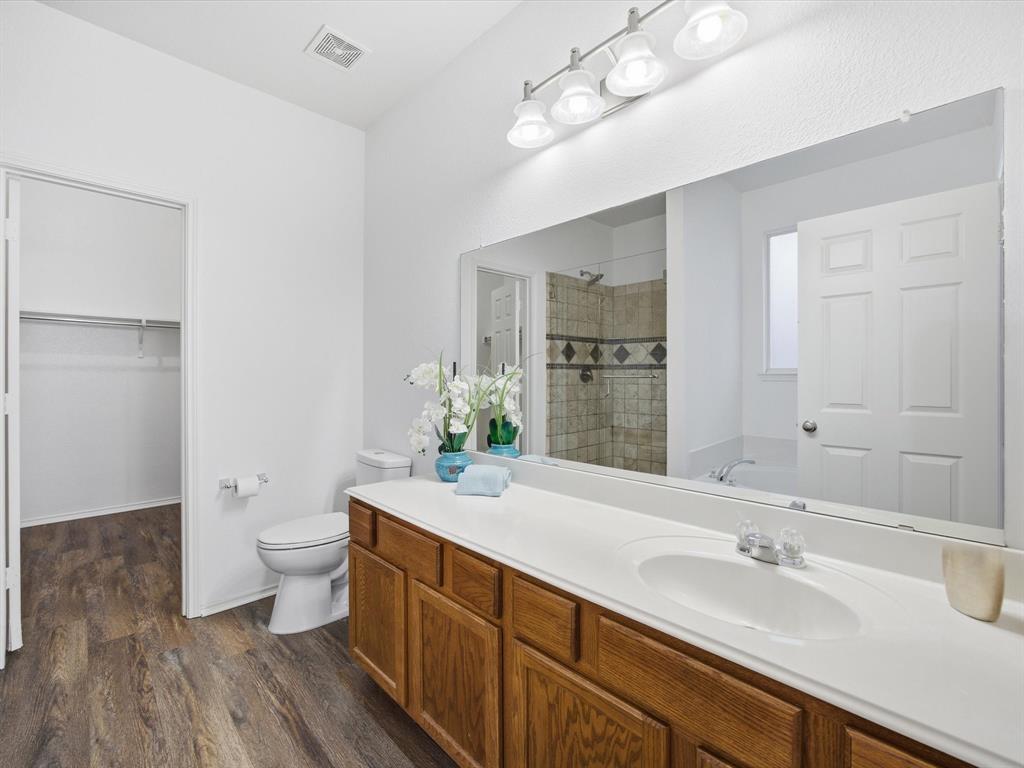 13264 Fencerow Road Fort Worth, TX 76244 - Photo 17 of 26 a spacious bathroom with a granite countertop sink a toilet and a large mirror