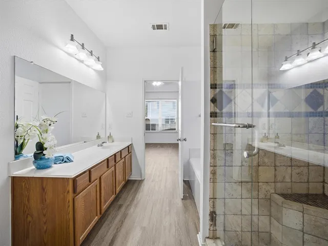a bathroom with a double vanity sink and a shower