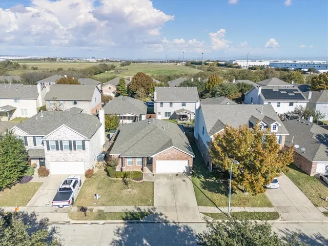 an aerial view of residential houses with outdoor space and ocean view