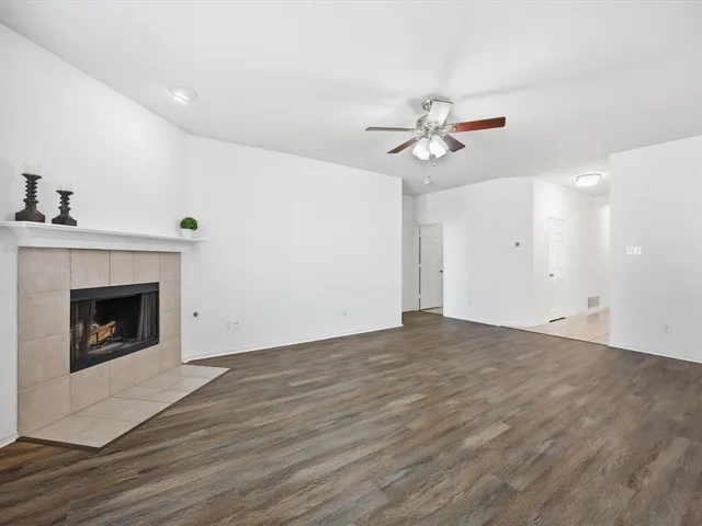 a view of empty room with wooden floor and fireplace