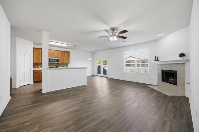 a view of a big room with wooden floor a kitchen view and a window