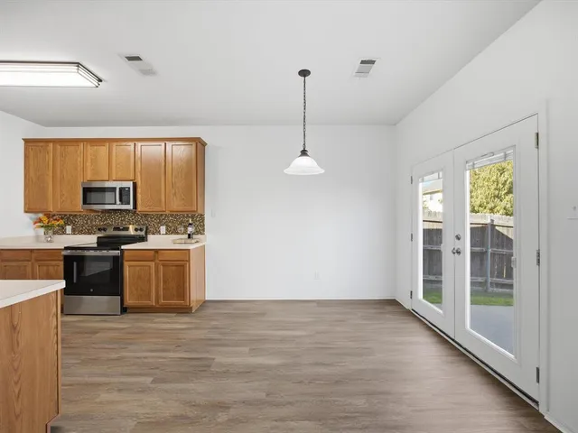 a kitchen with stainless steel appliances granite countertop a stove a sink and a refrigerator
