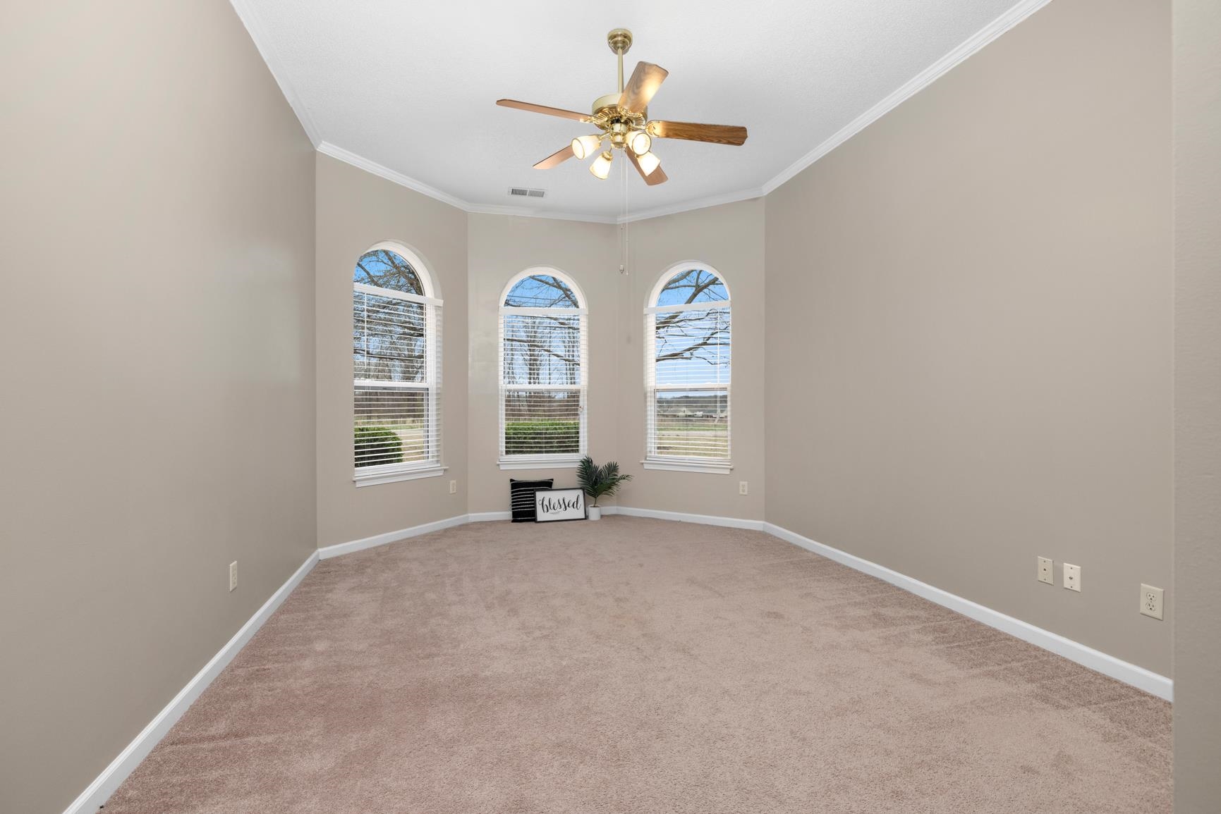 1355 Rosemark Road Atoka, TN 38004 - Photo 18 of 40 Spare room featuring visible vents, crown molding, baseboards, carpet floors, and a ceiling fan