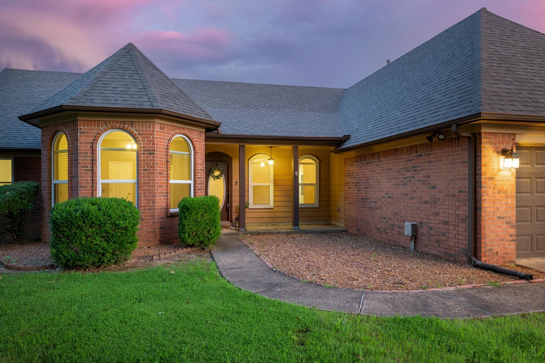 1355 Rosemark Road Atoka, TN 38004 - Photo 3 of 40 View of front of property featuring roof with shingles, brick siding, a garage, and a yard