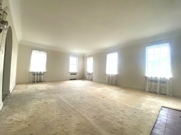 an empty room with windows and closet