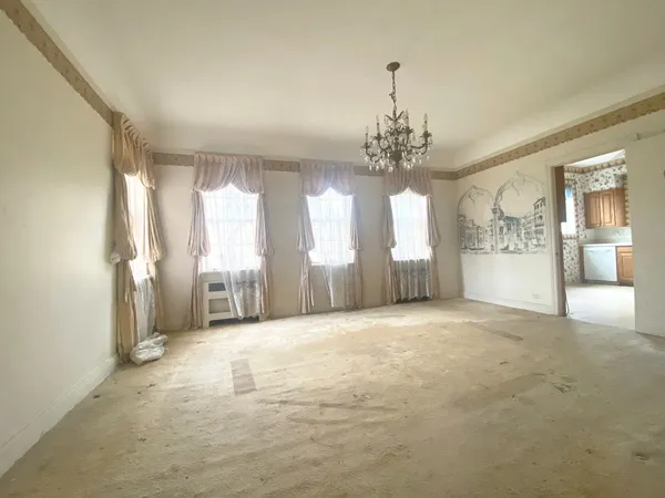 a view of a hallway with windows and chandelier