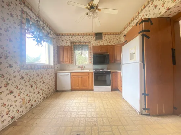 a large kitchen with a stove a refrigerator and a fireplace