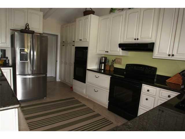 3333 Southeast Fairway East Stuart, FL 34997 - Photo 3 of 14 a kitchen with granite countertop white cabinets and stainless steel appliances