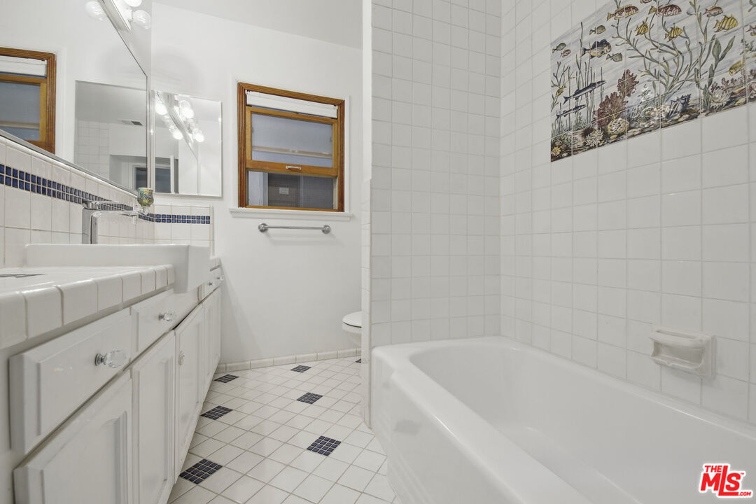 5527 Columbus Avenue Sherman Oaks, CA 91411 - Photo 20 of 29 a bathroom with a bathtub sink and mirror