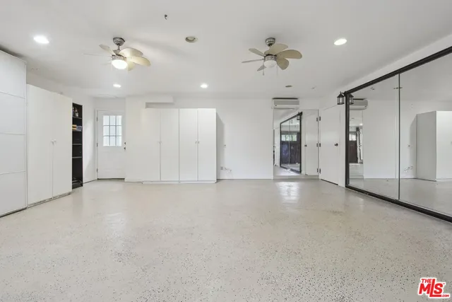 a view of an empty room with a ceiling fan and window