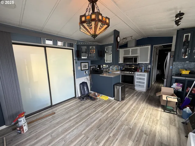a kitchen with a sink appliances and wooden floor