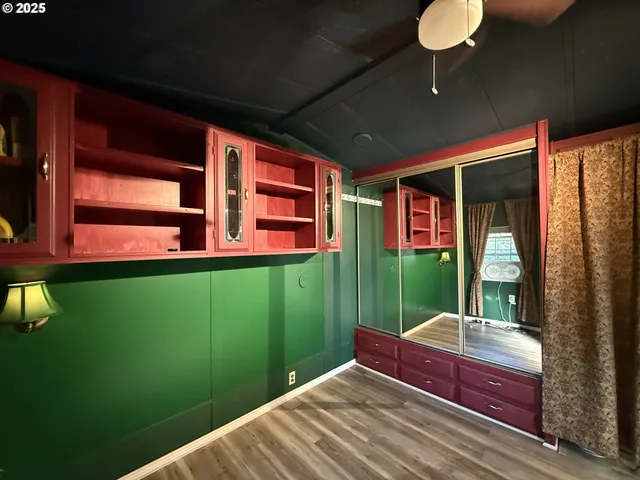 a bedroom with window and hardwood
