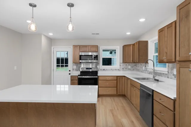 a large kitchen with granite countertop a large counter top stainless steel appliances and cabinets