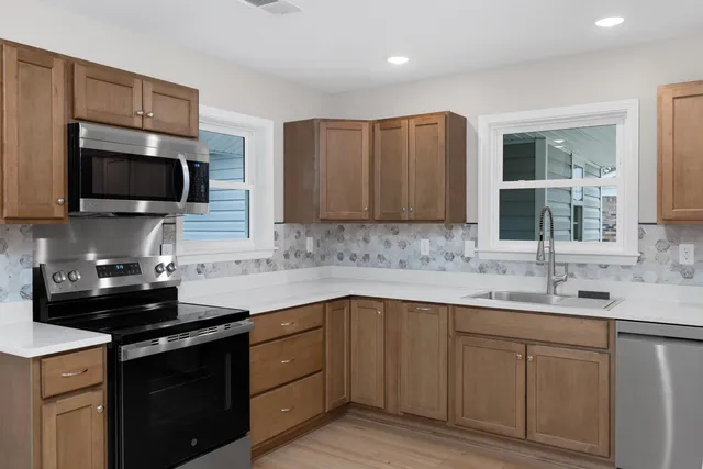 a large kitchen with kitchen island a sink stainless steel appliances and cabinets