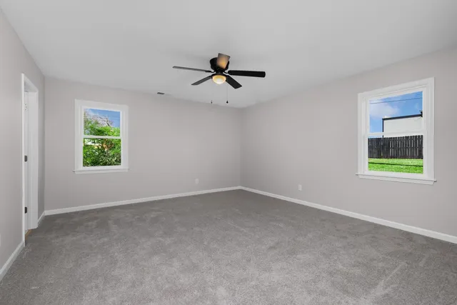 a large kitchen with a large counter top a sink stainless steel appliances and cabinets