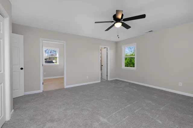 a view of a livingroom with a ceiling fan and window