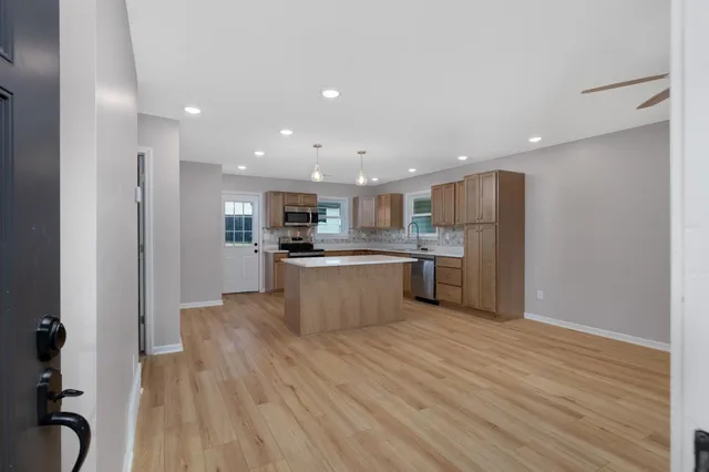 a kitchen with stainless steel appliances kitchen island wooden cabinets and granite counter tops