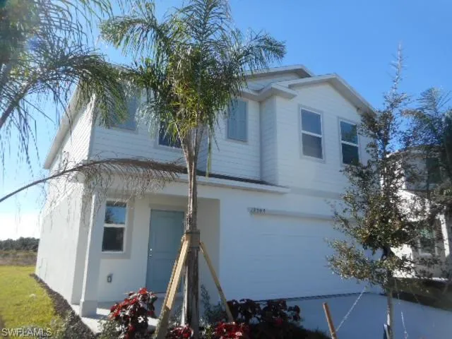 a front view of a house with a tree
