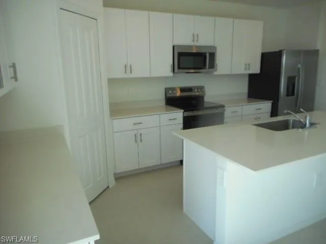 a kitchen with stainless steel appliances a stove microwave and refrigerator