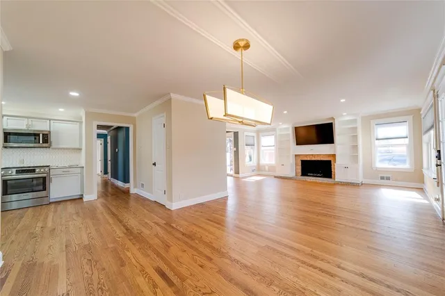 a view of kitchen with microwave a stove and wooden floor