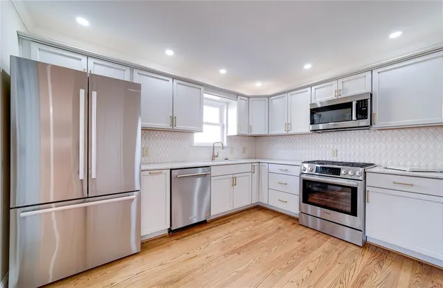 a kitchen with a refrigerator stove and wooden cabinets