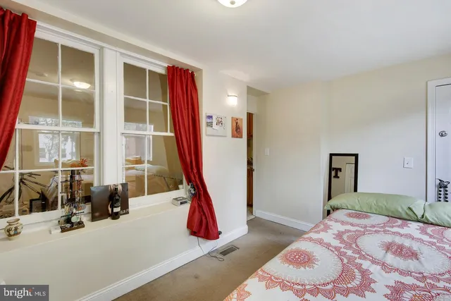 a bedroom with a bed and a large window