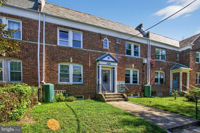 front view of a brick house with a yard