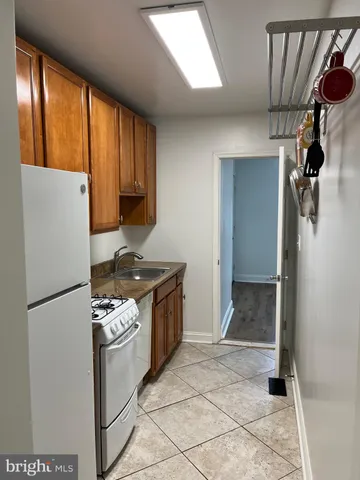 a kitchen with a refrigerator and a stove top oven