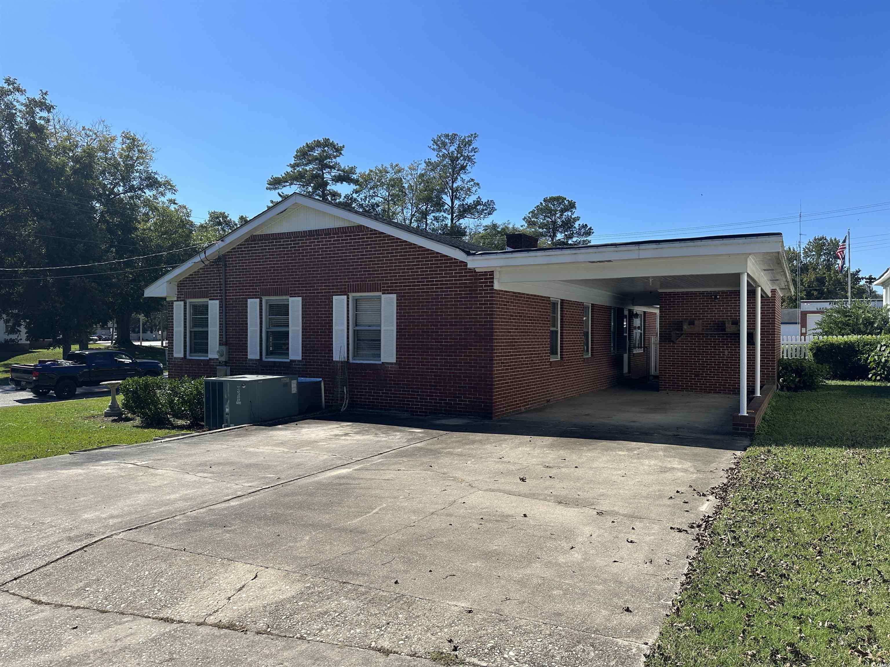 103 East 2nd Avenue Lake View, SC 29563 - Photo 3 of 16 View of side of property with brick siding, driveway, and a lawn