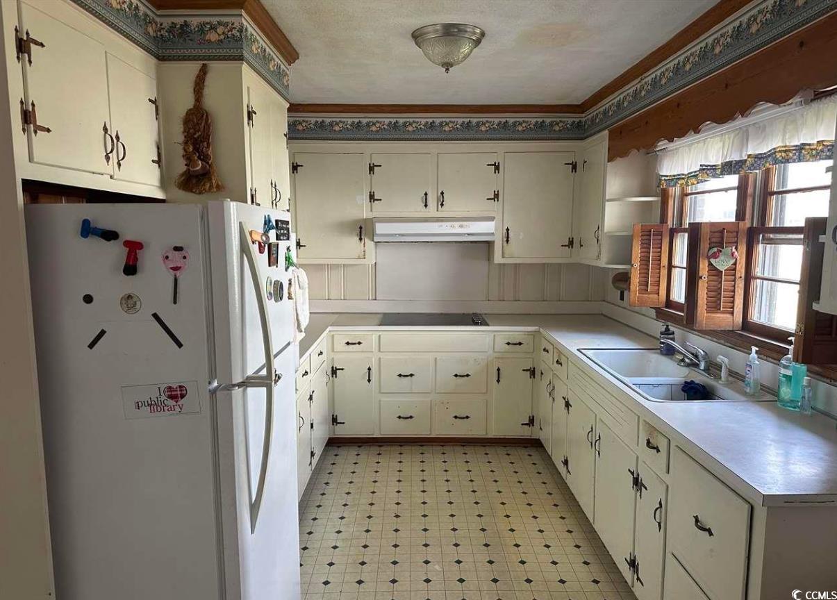103 East 2nd Avenue Lake View, SC 29563 - Photo 9 of 16 Kitchen with freestanding refrigerator, light countertops, light flooring, under cabinet range hood, and black electric stovetop