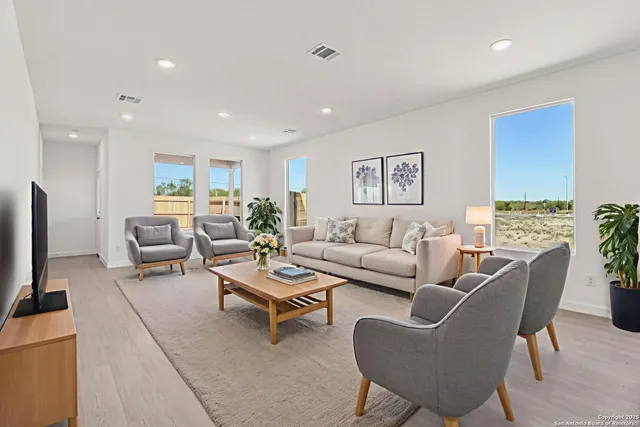 a living room with furniture wooden floor and a flat screen tv